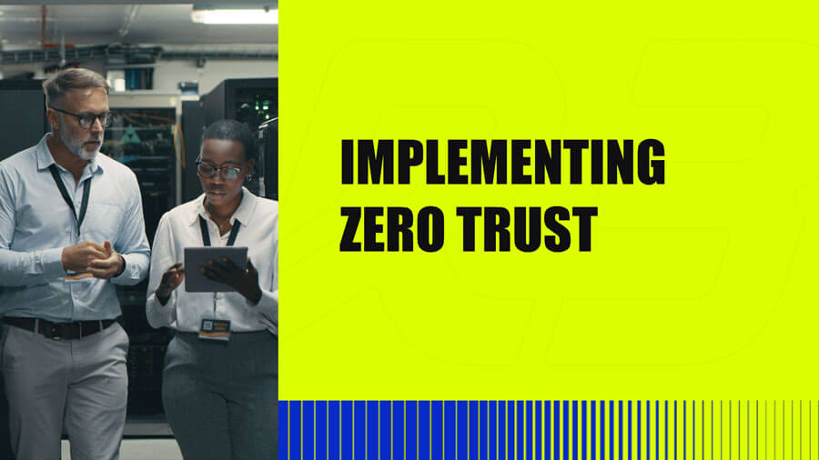 Two professionals, a man and a woman, stand in a server room discussing information on a tablet. Beside them, bold text reads IMPLEMENTING ZERO TRUST on a bright yellow background.
