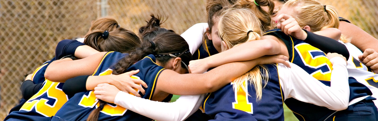 a group of girls on a sports team huddling