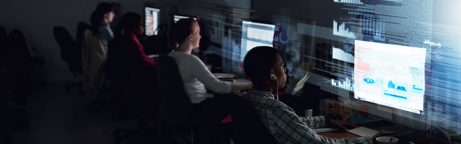 people working on their computers in a dark room