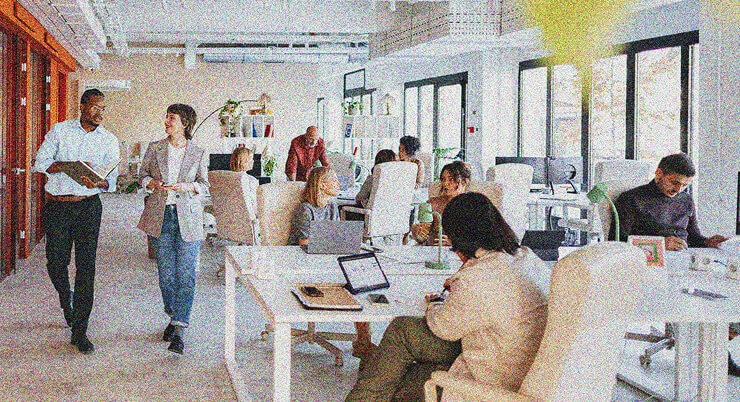 a busy work office with people talking and smiling together