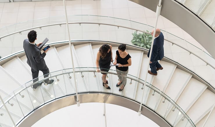 people walking and talking on a grand staircase