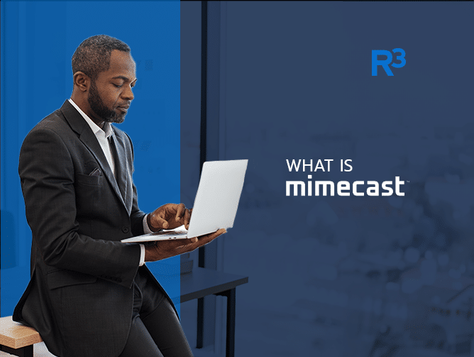 A man in a suit sits at a desk, working on a laptop. The text What is Mimecast appears alongside the R³ logo, set against a blurred office background.